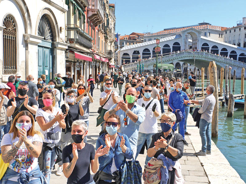 إيطاليون يتظاهرون في البندقية أمس احتجاجاً على استمرار الإغلاق       (اي بي ايه)