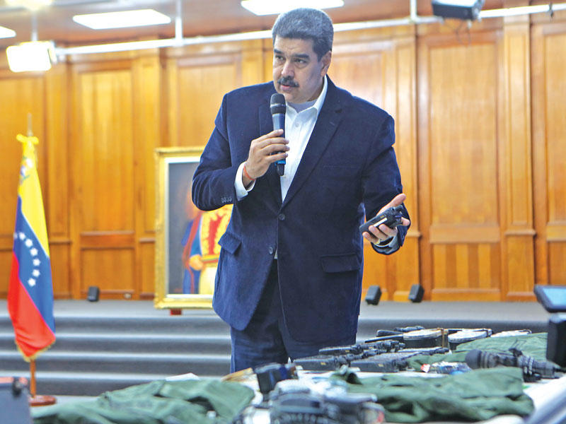 الرئيس الفنزويلي نيكولاس مادورو يعرض أجهزة وبطاقات يقول إنها تعود لمجموعة حاولت التسلل إلى البلاد  (إي بي أيه)