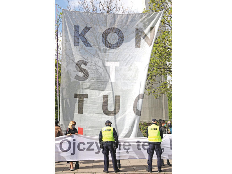 لافتة كتب عليها «الدستور» في اعتراض على إجراء الانتخابات الرئاسية عبر البريد أمام مقر البرلمان في وارسو أمس (إي بي أيه)