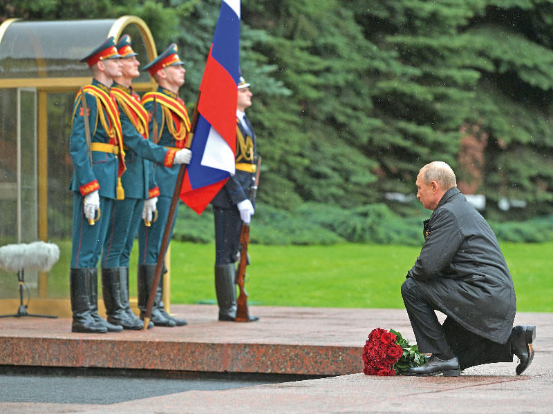 بوتين راكعاً أمام ضريح الجندي المجهول وبيده باقة زهور في موسكو أمس  (رويترز)