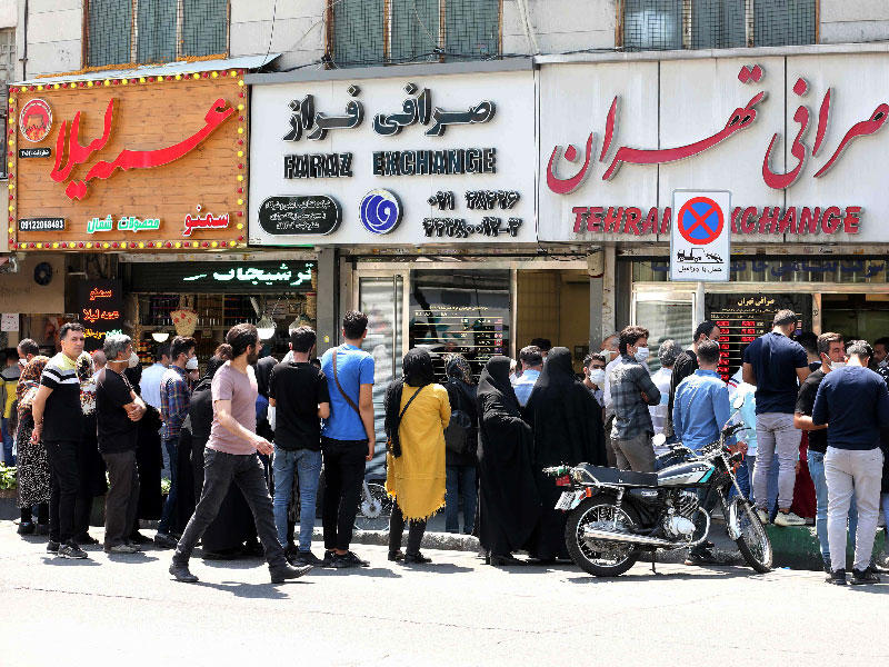 إيرانيون ينتظرون دورهم أمام محل صرافة في طهران (أ ف ب)