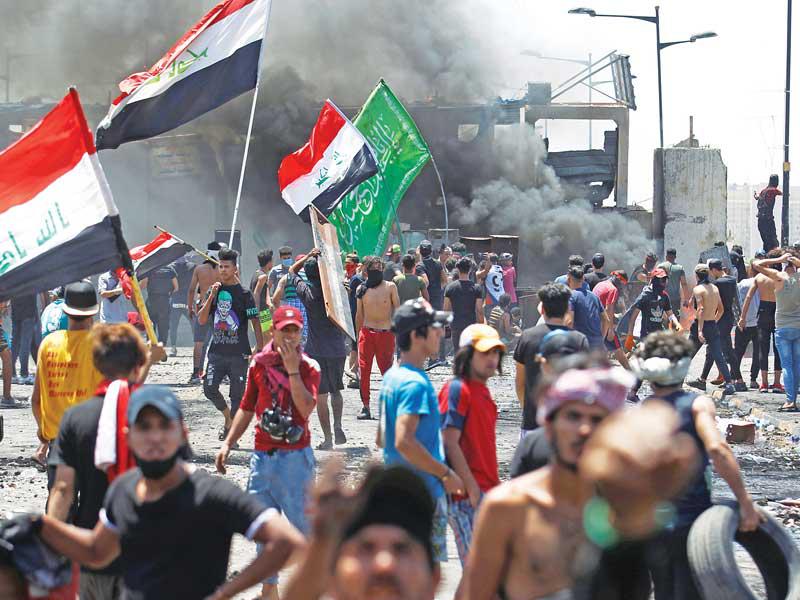متظاهرون عراقيون على جسر الجمهورية في بغداد (رويترز)n