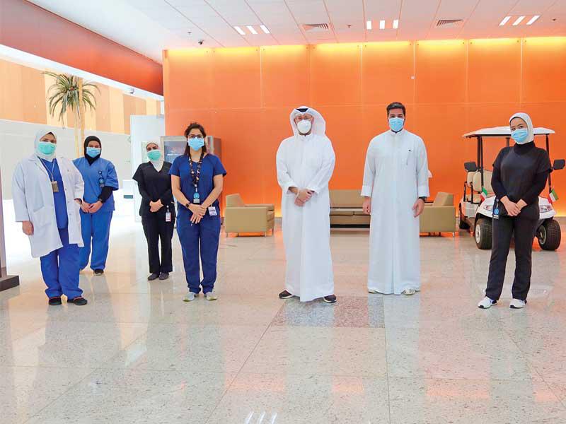  مدير أول إدارة الاتصال المؤسسي في Ooredoo الكويت مجبل الأيوب ومحمد ميرزا في لقطة جماعية مع العاملين بالصفوف الأمامية