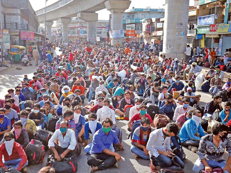 آلاف العمال الهنود يتجمعون في أحمد آباد خلال مسيرة طويلة للعودة إلى قراهم بسبب توقف الأعمال       (رويترز)