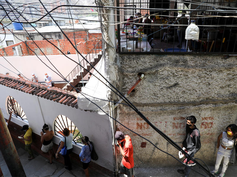 فنزويليون ينتظرون دورهم للحصول على مساعدات غذائية في كراكاس      (رويترز)