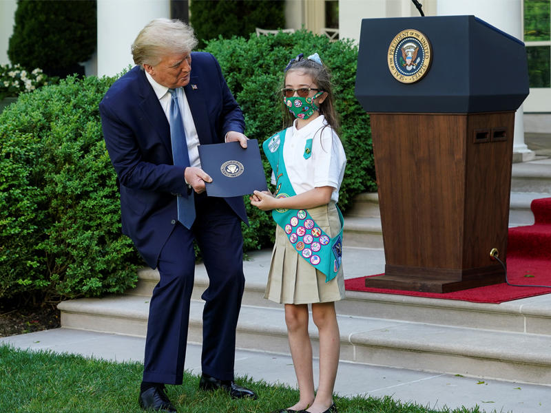 ترامب يسلم إلى طفلة أميركية في الكشافة رسالة تقدير خلال احتفال بالبيت الأبيض أمس الأولt(رويترز)