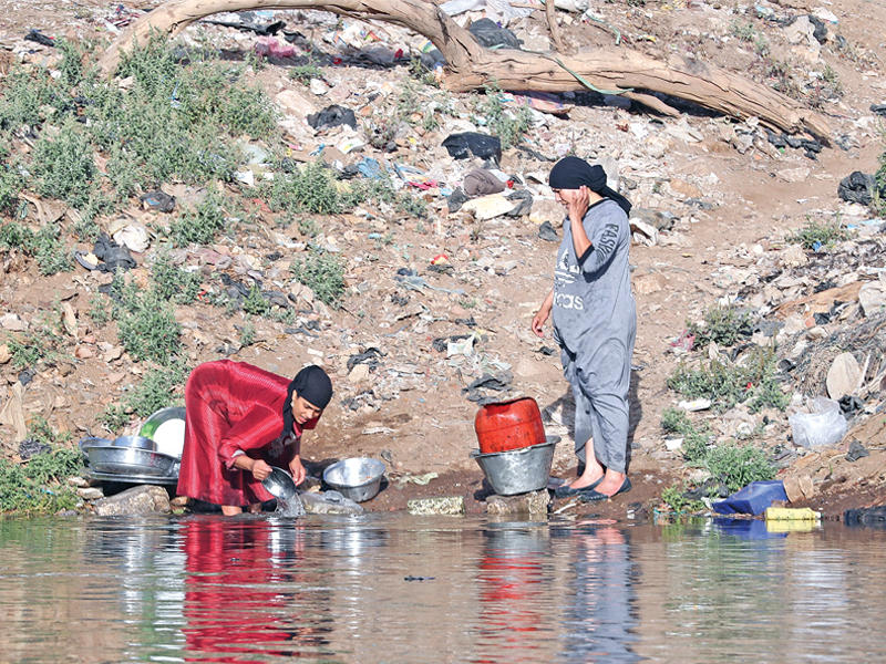 مصريتان تغسلان اطباقاً في النيل بطنطا أمس   (أي بي أيه)