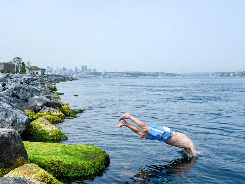 شاب يمارس السباحة في أحدى السواحل التركية المطلة على البحر المتوسط