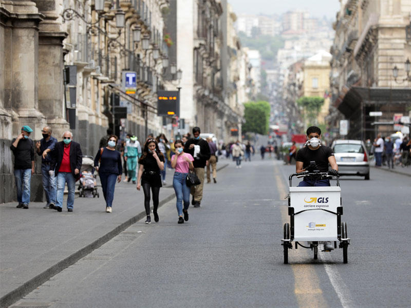 موظف بريد في وسط أحد شوارع مدينة كاتانيا الإيطالية أمس (رويترز)