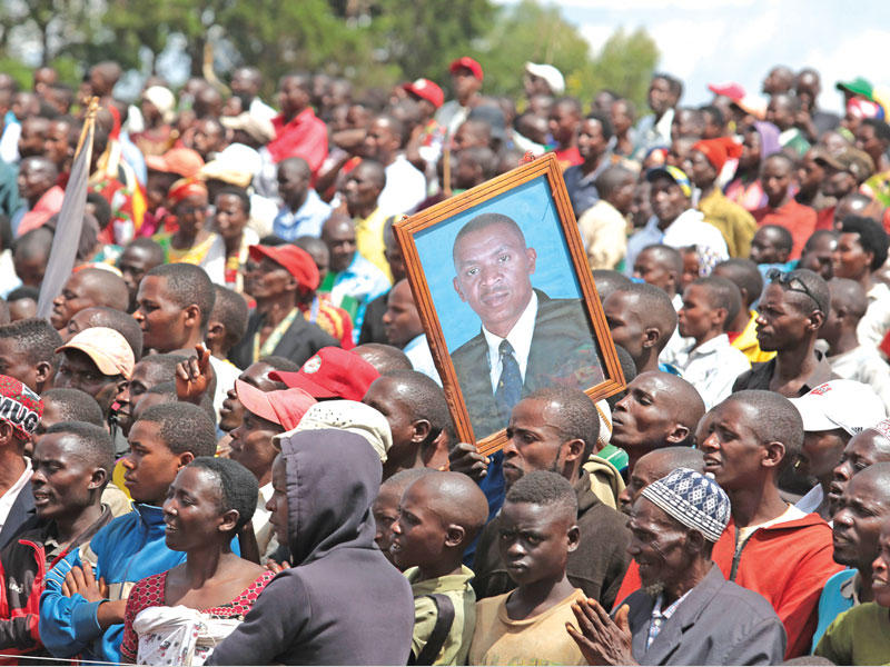 أحد المؤيدين يحمل صورة لأغاثون رواسا المرشح الرئاسي لحزب المعارضة الرئيسي حزب المؤتمر الوطني من أجل الحرية (CNL) 