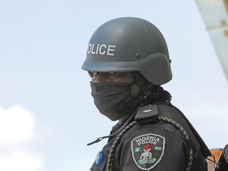 شرطي يرتدي قناع وجه وقائي أثناء صد مقاتلي التنظيم مع استمرار انتشار فيروس كورونا في نيجيريا.