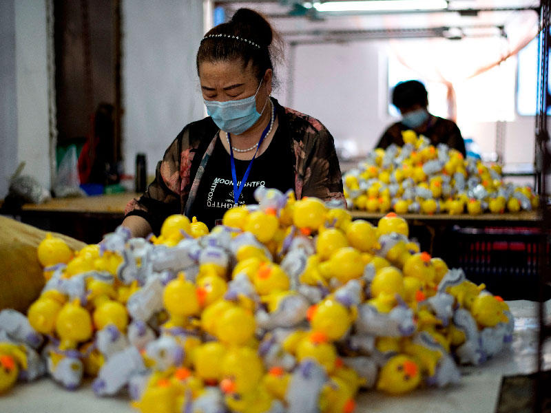 عمال يرتدون أقنعة الوجه يقومون بتجميع الألعاب في مصنع للألعاب في شانتو جنوب الصين