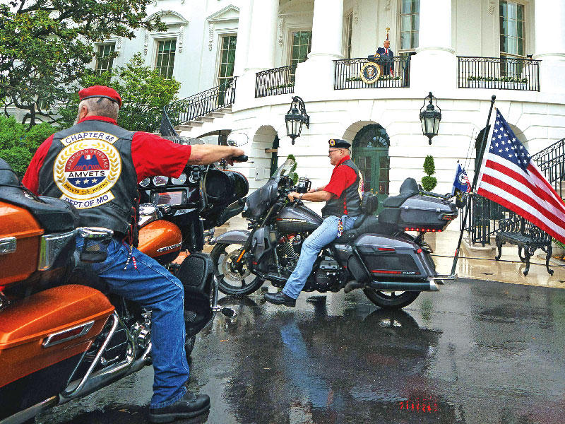 ترامب على شرفة البيت الأبيض يحيي راكبي دراجات خلال إحياء يوم المقاتلين أمس الأول (أ ف ب) 