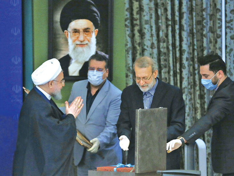 روحاني مكرماً لاريجاني خلال افتتاح البرلمان أعماله في طهران أمس               (إرنا)