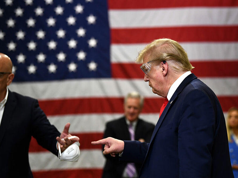 الرئيس الأمريكي دونالد ترامب رافضاً ارتداء كمامة طبية أثناء جولته في مصنع هاني ويل الذي ينتج أقنعة N95 (5 مايو 2020)