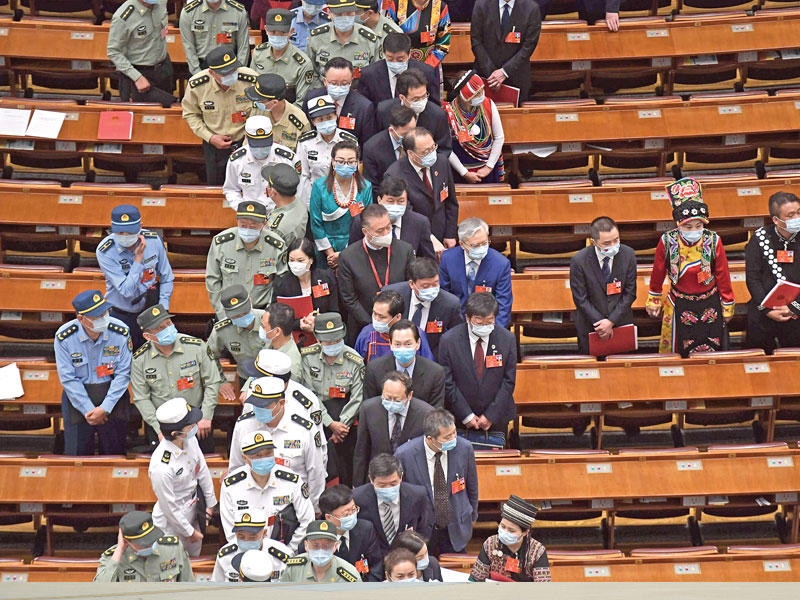 نواب صينيون يغادرون أمس مقر مجلس الشعب ببكين بعد انتهاء الجلسة السنوية التي استمرت أياماً (أ ف ب)