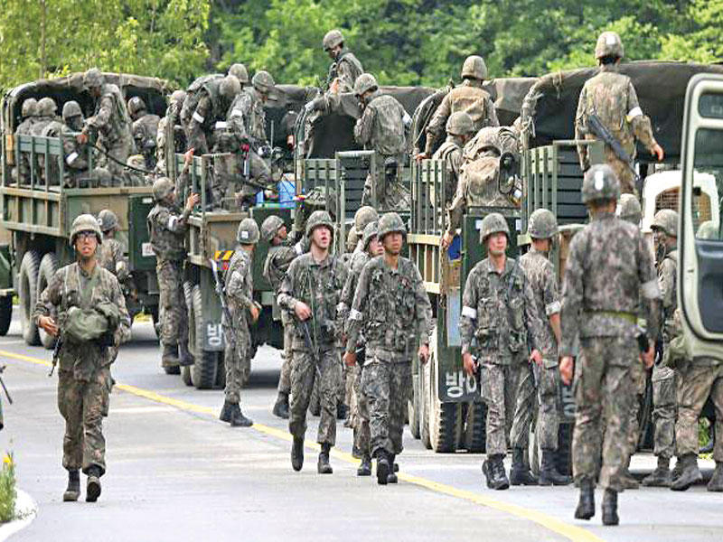 جنود الجيش الكوري الجنوبي يخرجون من شاحناتهم العسكرية خلال عملية اعتقال في غوسونغ ، كوريا الجنوبية 