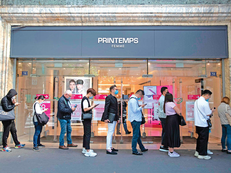 عملاء ينتظرون بالصف للدخول إلى أحد متاجر باريس أمسt (أ ف ب)