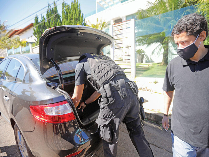 الشرطة الاتحادية البرازيلية تقوم بتفتيش احد السيارات امام منزلا بالعاصمة برازيليا