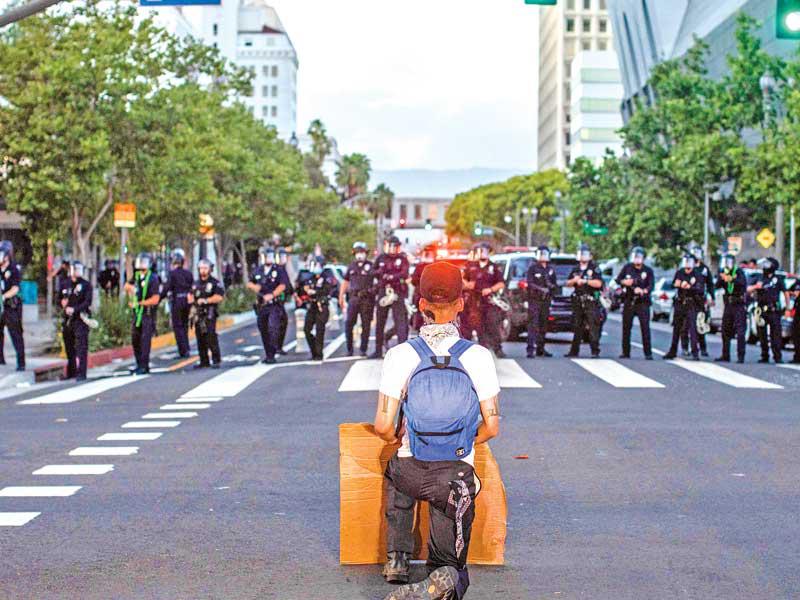 محتج يغلق بمفرده طريقا امام الشرطة في لوس أنجلس أمس الأول (أ ف ب)
