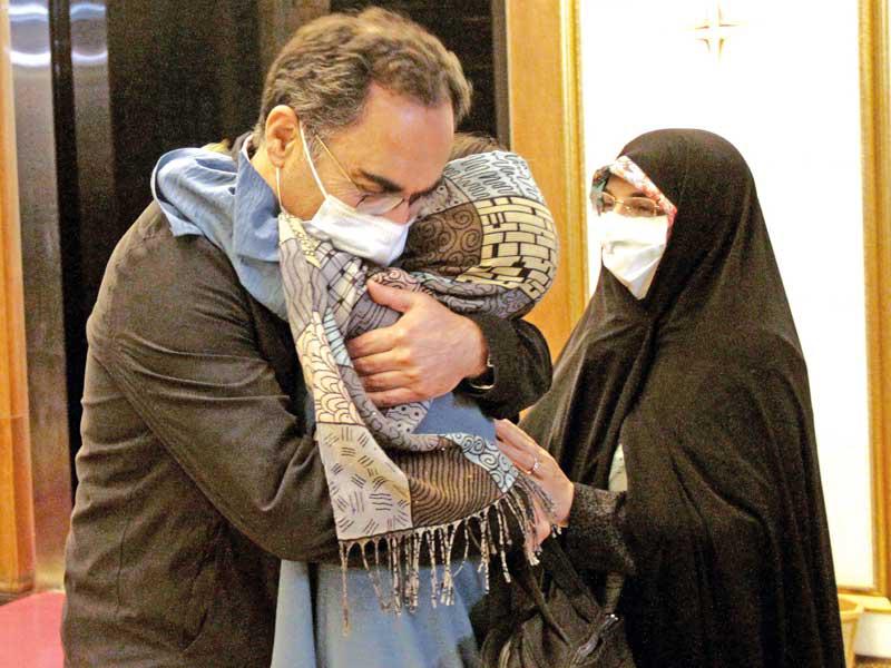 عسكري معانقاً أفراداً من عائلته لدى وصوله إلى مطار الخميني في طهران أمس (رويترز)