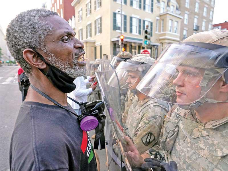 رجل أسود يصرخ بوجه أحد الجنود في واشنطن أمس (رويترز)