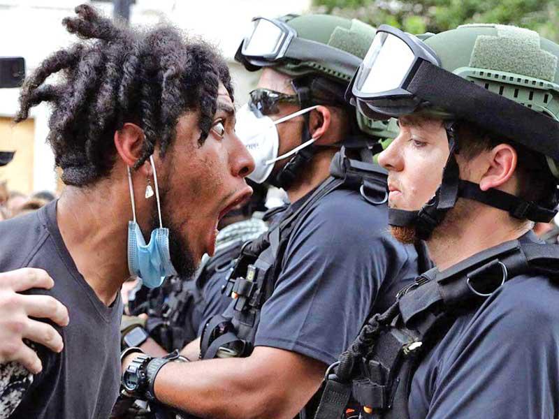 محتج يواجه شرطياً اميركي