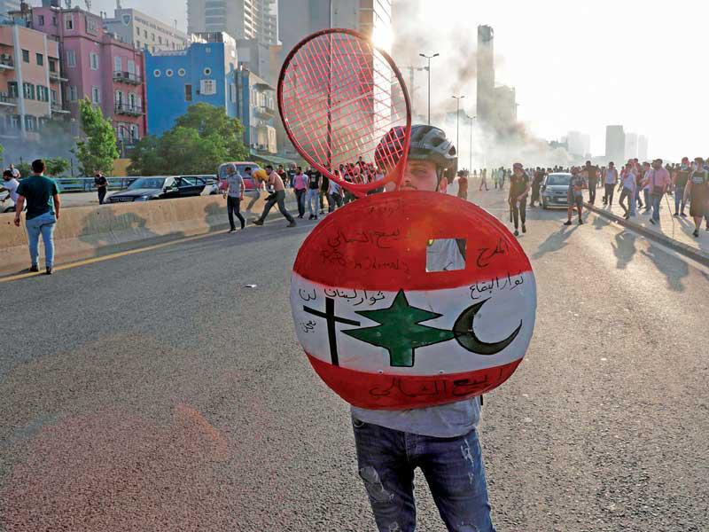 محتج لبناني يحمل درعاً رسم عليها الصليب والهلال قبيل الاشتباكات المذهبية ليل السبت - الأحد (أ ف ب) 