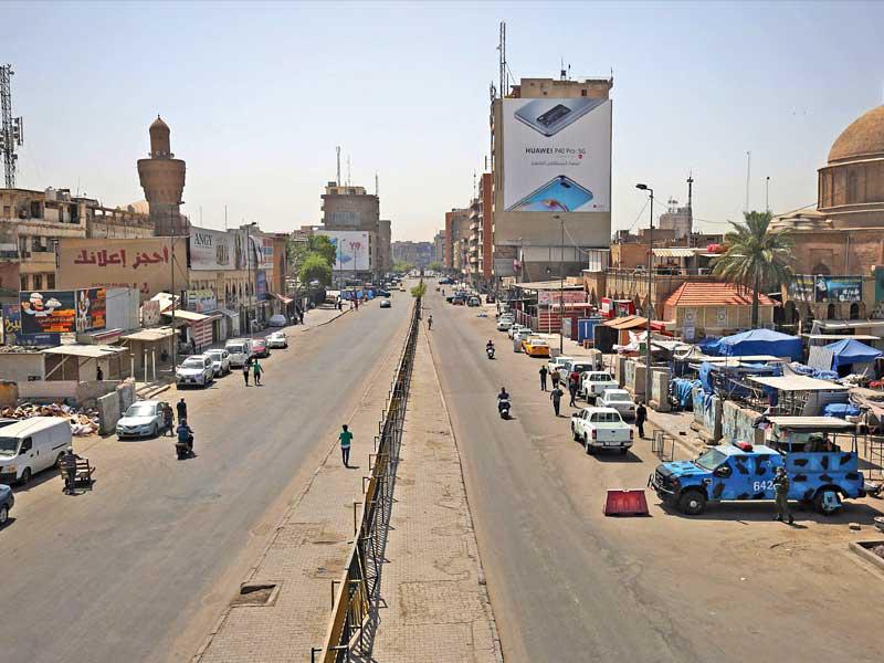  نقطة أمنية لمراقبة حظر التجوّل المفروض بسبب «كورونا» في بغداد أمس (ا ف ب) 