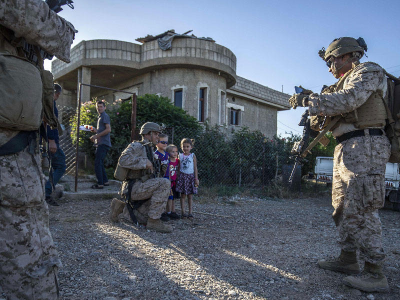 جنود أميركيون يلتقطون صوراً مع أطفال سوريين في المالكية شمال شرق سورية أمس الأول t(أ ف ب)n