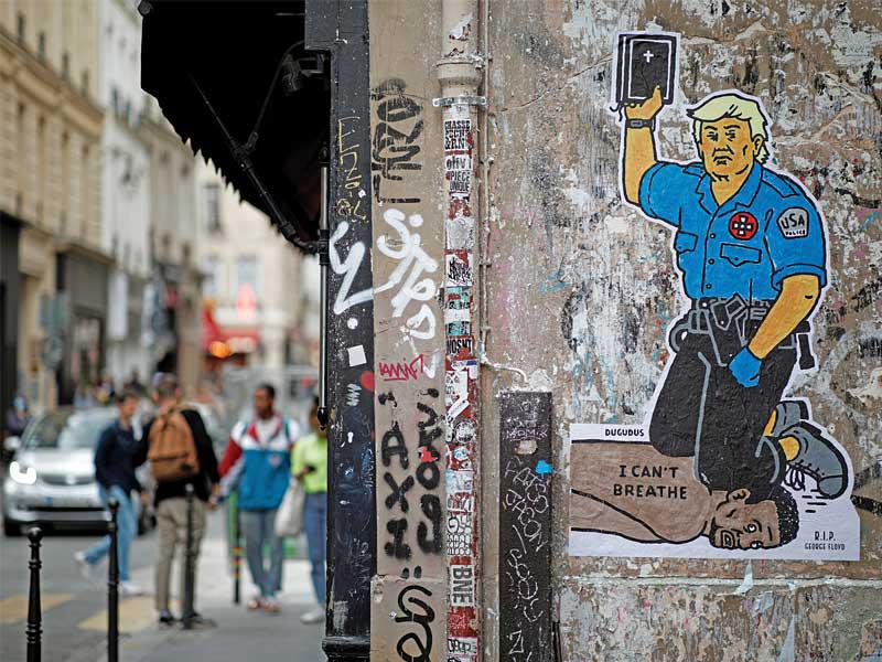 جدارية للفنان الفرنسي دوغودو في باريس تظهر ترامب جاثماً بركبته على عنق فلويد ورافعاً الإنجيل بيده                                    (رويترز)