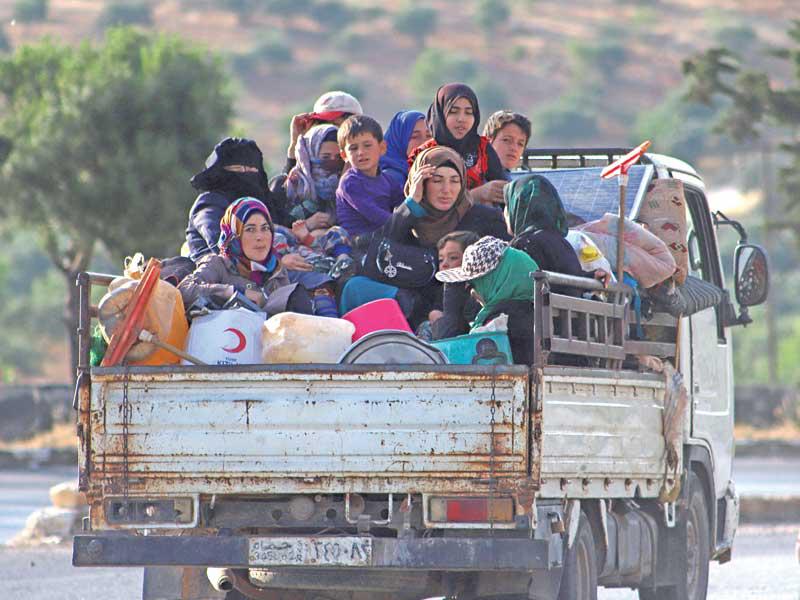 مدنيون سوريون يهربون بشاحنة من منطقة إدلب أمس الأول t(أ ف ب)