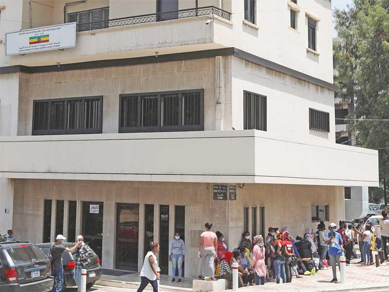 عاملات إثيوبيات ينتظرن قرب سفارتهن في بيروت أمس الأولt (رويترز)