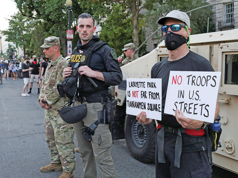 ضباط إنفاذ القانون يقفون حراسة خلال احتجاج ضد عدم المساواة العرقية في أعقاب وفاة شرطة مينيابوليس في حجز جورج فلويد 