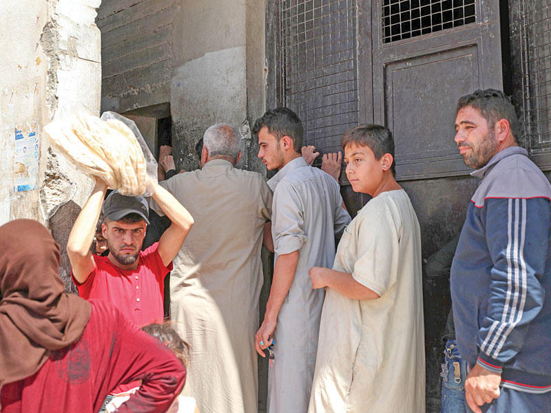 سوريون في بنّج ينتظرون بالدور لشراء الخبز أمس الأول (ا ف ب)