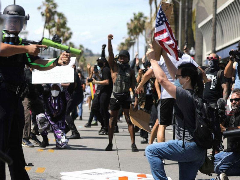 ضابط يهدف بسلاح غير مميت خلال مواجهة مع المتظاهرين بعد وفاة جورج فلويد ، 30 مايو 2020 ، في لوس أنجلوس