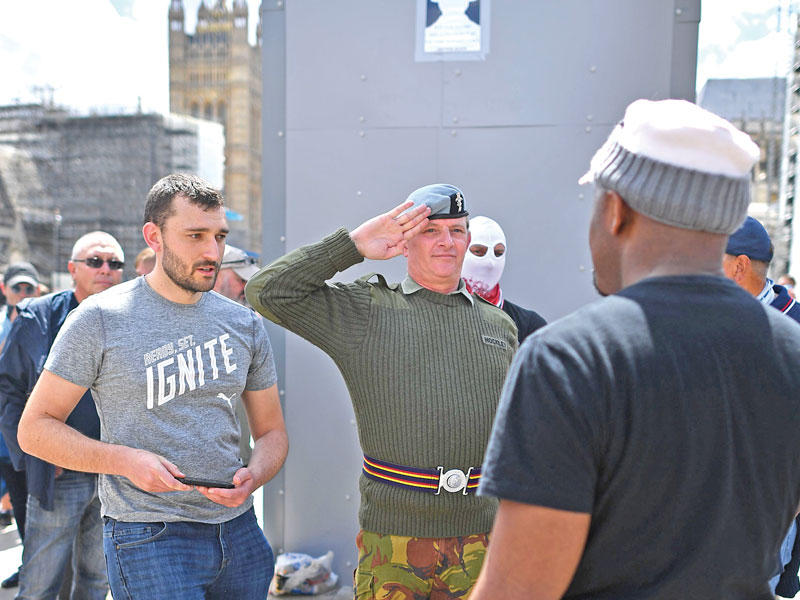 يمينيون يحرسون تمثال تشرشل بساحة البرلمان في لندن أمس (أ ف ب) 