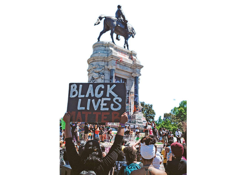 متظاهرون أميركيون أمام تمثال القائد العسكري الكونفدرالي الأشهر روبرت أي لي، في مدينة ريتشموند بفرجينيا، أمس الأولtt       (أ ف ب)