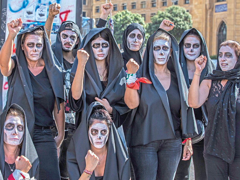 لبنانيون لبسوا الأسود وصبغوا وجوههم بالأبيض خلال جنازة رمزية «للوطن» في وسط بيروت أمس الأول (اي بي ايه)