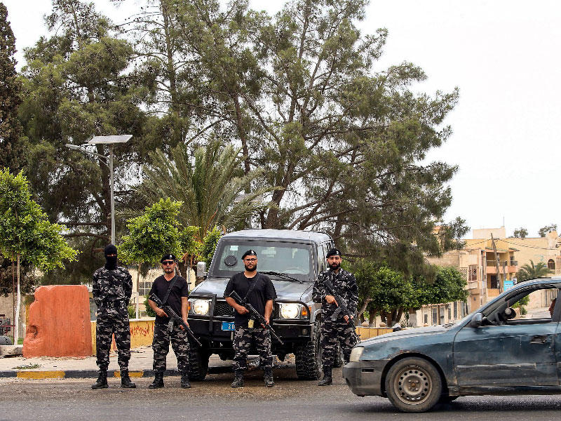 أفراد من قوات الأمن التابعة لوزارة الداخلية في حكومة الوفاق الوطني الليبي يقفون عند نقطة تفتيش مؤقتة