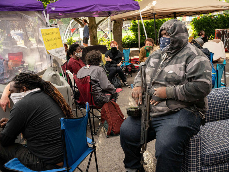 مسلح مؤيد للمحتجين في «المنطقة ذاتية الحكم» المعلنة في سياتل أمس الاول (أ ف ب)