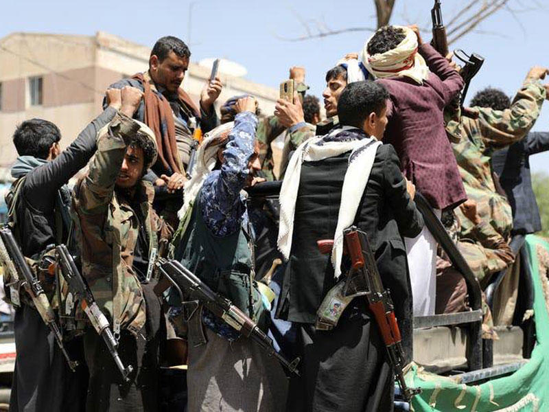مسلحون من الميليشيات الحوثية يركبون على ظهر شاحنة خارج مستشفى في صنعاء 