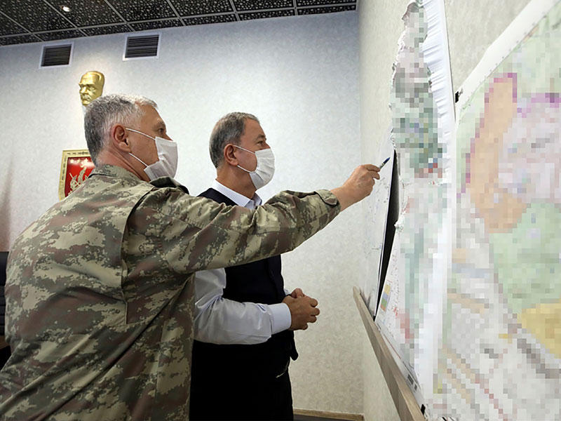 وزير الدفاع التركي خلوصي آكار يستعرض خريطة تظهر مناطق عمليات «مخلب النمر» في أنقرة أمس (أ ف ب)