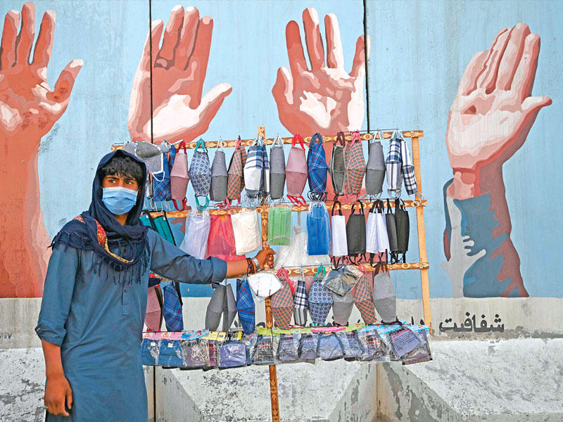 أفغاني يبيع الكمامات في كابول امس (ا ف ب)