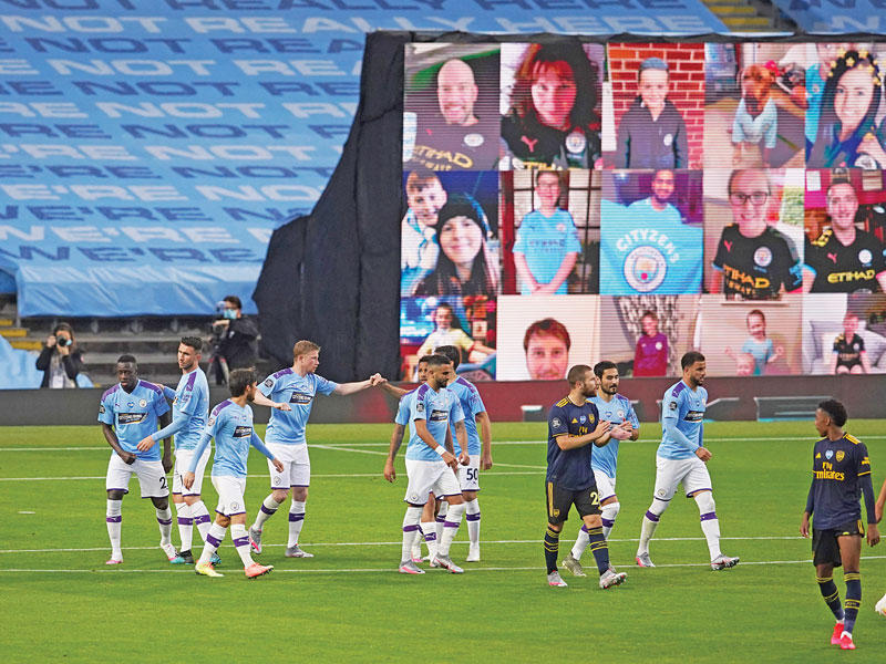 لاعبو مانشستر سيتي يحتفلون بعد إحراز الهدف الثاني في مرمى أرسنال وبالخلف يبدو عدد من جماهير السيتي يؤازرون الفريق عبر الشاشات الإلكترونية