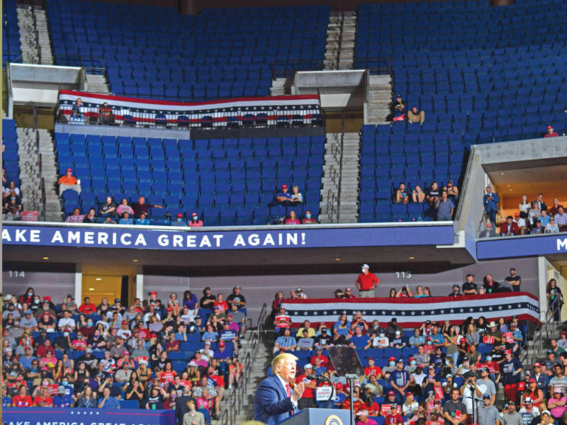 ترامب خلال التجمع في تولسا أمس في صورة تركز على المقاعد الفارغة (أ ف ب) 