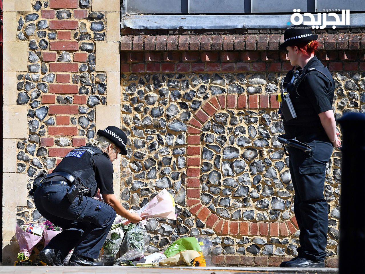 شرطيات يضعن باقة من الزهور في موقع سقوط الضحايا