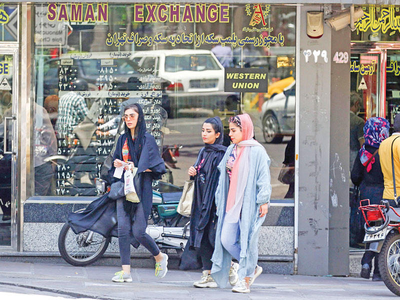 إيرانيات أمام محل صرافة في طهران مع استمرار تدهور سعر صرف التومان (أ ف ب)