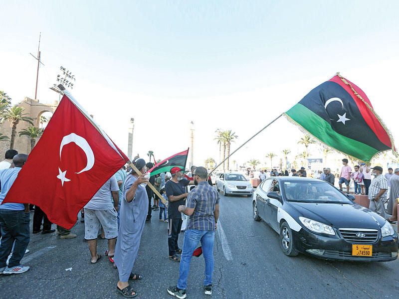 مؤيدون لأنقرة يحملون أعلاماً ليبية وتركية بطرابلسt(أ ف ب) 