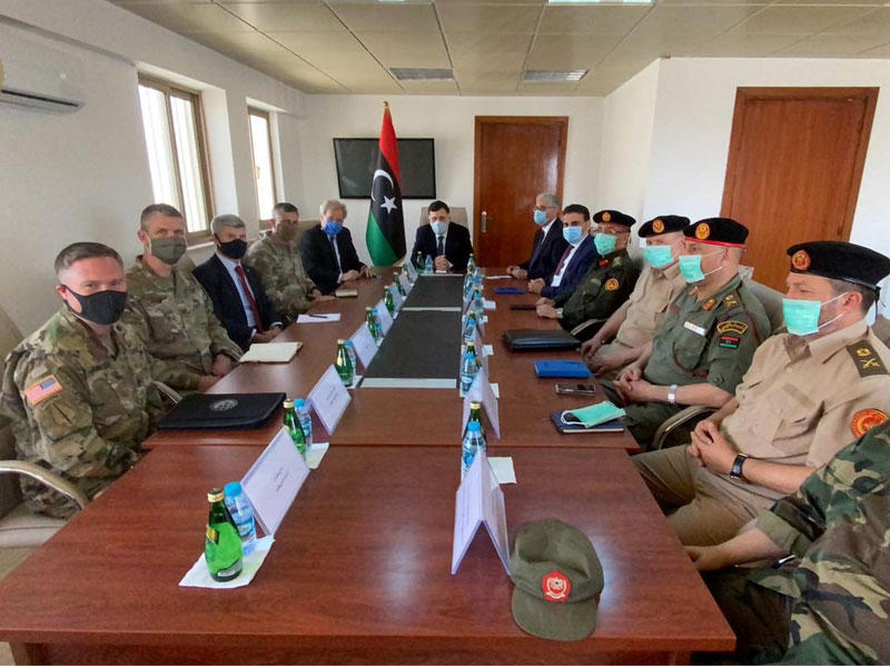  السراج وضباط من قواته خلال اجتماع مع سفير واشنطن وقائد «أفركيوم» قرب طرابلس أمس الأول (رويترز) 